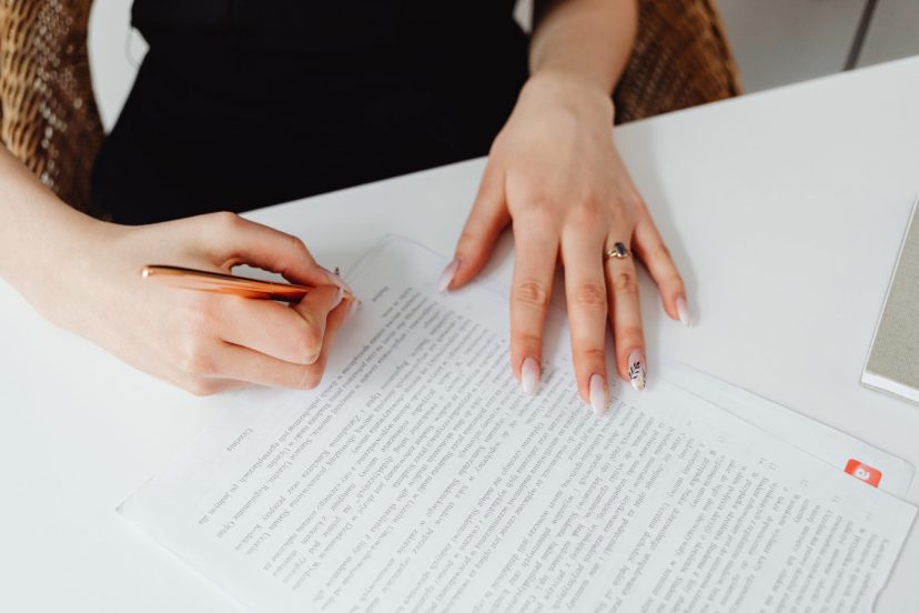 woman signing paperwork on left side in front of notary public