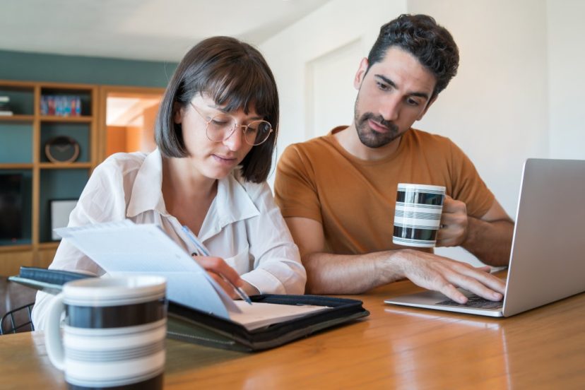 Portrait of young couple completing tax return on laptop from home Portrait of young couple completing tax return on laptop from home wondering Should I File My Tax Return with My Spouse in Canada?