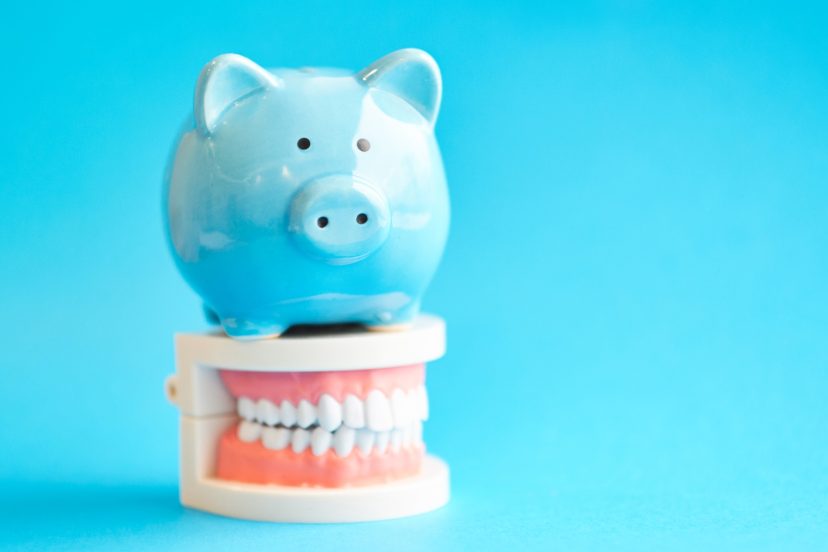 Piggy bank with White teeth model on blue background. tax offset concept.